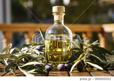 Olive oil with olive tree branch background. Natural oil for food or cosmetics from natural ingredients. Healthy food, cosmetics concept. Olive oil with olive tree branch background. Natural oil for food or cosmetics from natural ingredients. Healthy food, cosmetics concept. 96660002