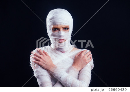 Glamorous mummy woman in bandages all over her body studio black background Glamorous mummy woman in bandages all over her body studio black background 96660429