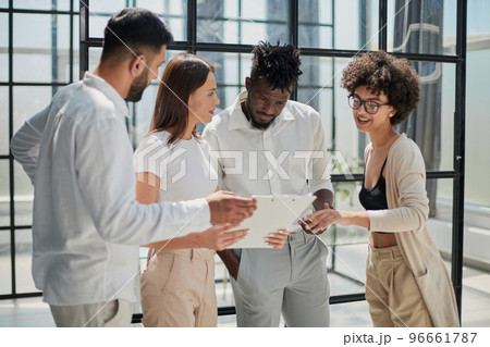 Employees working at computer together, discussing content 96661787