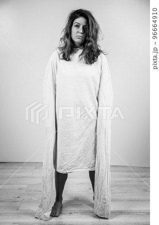 Close-up portrait of insane woman in straitjacket on white background. Monochrome. Close-up portrait of insane woman in straitjacket on white background. Monochrome. 96664910