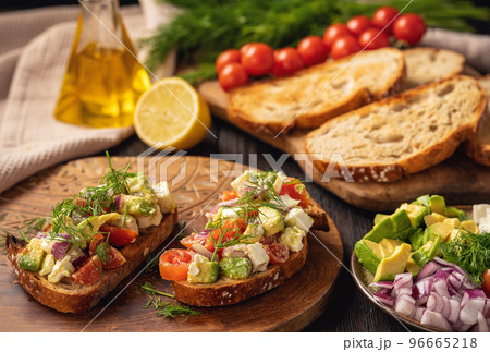 Tasty and healthy avocado, cherry tomatoes and feta cheese sandwiches. Toasts with avocado, tomatoes and feta cheese. Tasty and healthy avocado, cherry tomatoes and feta cheese sandwiches. Toasts with avocado, tomatoes and feta cheese. 96665218