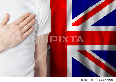English person with hand on heart on the background of UK flag. English person with hand on heart on the background of UK flag. 96665496