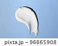 Liquid white cream smear isolated on blue background. Beauty cosmetic smudge such as hair conditioner, creamy lotion, facial retinol serum, mask balm, cleanser, shower gel or shampoo top view 96665908