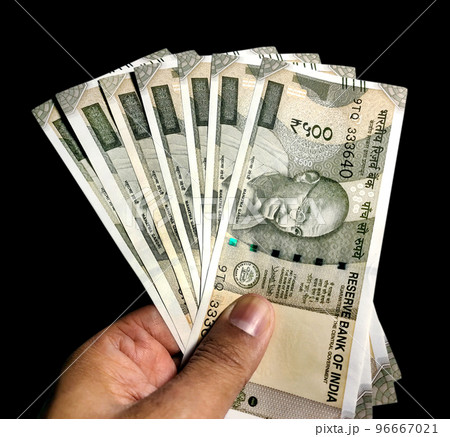 Hand holding five hundred Indian rupee notes against white background Hand holding five hundred Indian rupee notes against white background 96667021