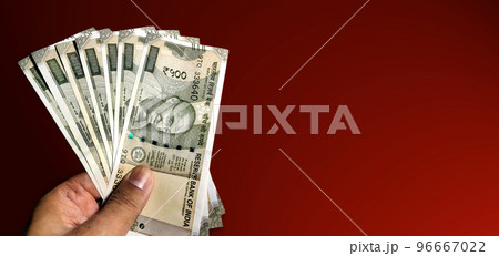 Hand holding five hundred Indian rupee notes against white background Hand holding five hundred Indian rupee notes against white background 96667022