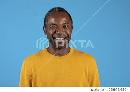 Headshot of handsome black man winking on blue 96668432