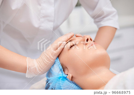 woman receiving facial massage at spa salon 96668975