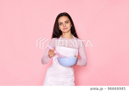 woman holding whisk and bowl with eggs woman holding whisk and bowl with eggs 96668985