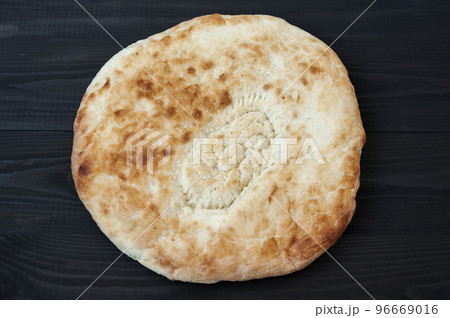 Wheat tortilla with sesame seeds on black wooden table. Wheat tortilla with sesame seeds on black wooden table. 96669016