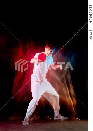 young man playing table tennis in mixed neon light 96669055