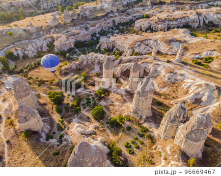 Colorful hot air balloons flying over at fairy chimneys valley in Nevsehir, Goreme, Cappadocia Turkey. Spectacular panoramic drone view of the underground city and ballooning tourism. High quality Colorful hot air balloons flying over at fairy chimneys valley in Nevsehir, Goreme, Cappadocia Turkey. Spectacular panoramic drone view of the underground city and ballooning tourism. High quality 96669467