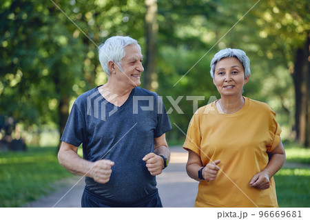 Older couple jogging in the summer park 96669681