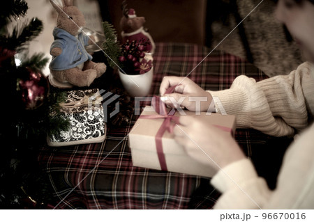 young woman wrapping a gift box young woman wrapping a gift box 96670016