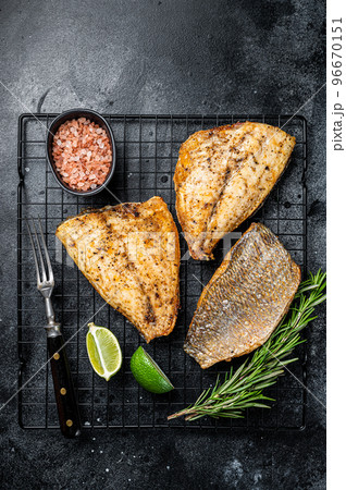 Baked Dorado Sea Bream fillets. Black background. Top view Baked Dorado Sea Bream fillets. Black background. Top view 96670151