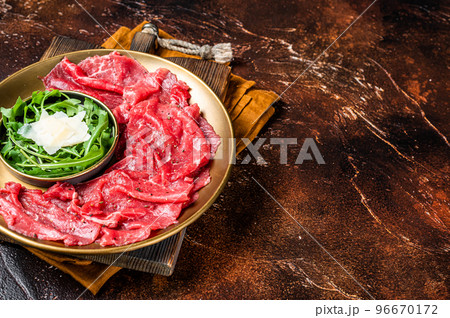 Carpaccio Beef meat appetizer with parmesan and arugula. Dark background. Top view. Copy space 96670172