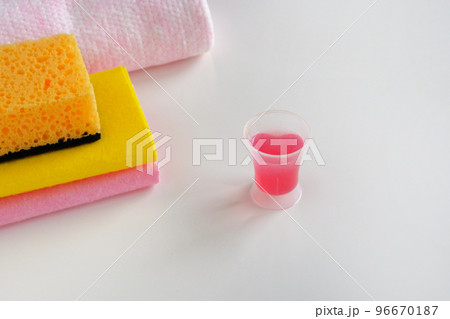 Cleaning concept. Detergent for cleaning room. Measuring plastic cup with pink liquid cleaning agent and cloth wipes. Cleanup housework. 96670187