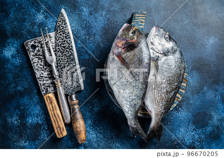 Sea bream or dorado fish on fish market cutting board. Blue background. Top view 96670205