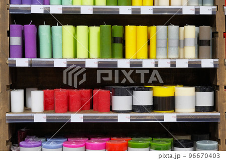 Candles for sale in interior decorating store. Coloured variety paraffin candles in cozy candle shop. Discounts on price tags, sale. 96670403