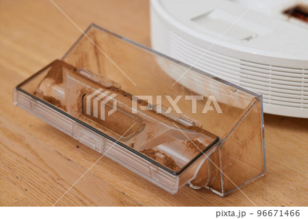 Cleaning the filter of the vacuum robot cleaner from dirt, close-up. Cleaning the filter of the vacuum robot cleaner from dirt, close-up. 96671466