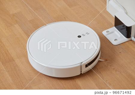 robotic vacuum cleaner on a laminated wooden floor Smart floor cleaning technology Charging dock station Concept. 96671492