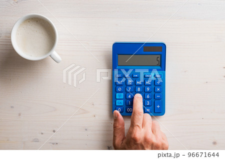 Top view of male hand using blue calculator Top view of male hand using blue calculator 96671644