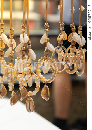 Jewelery showcase sea decorations on street market. Woman choosing decorations on local street market in Gdansk, Poland. Female tourist is choosing souvenirs in street shop and looking at color Jewelery showcase sea decorations on street market. Woman choosing decorations on local street market in Gdansk, Poland. Female tourist is choosing souvenirs in street shop and looking at color 96672218