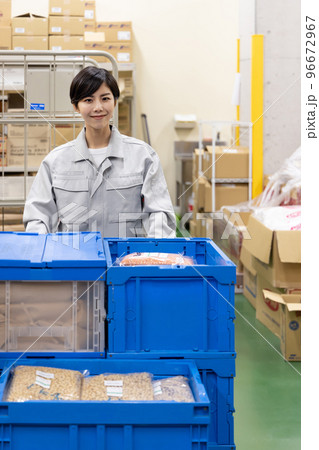 物流・運送業界　台車で荷物を運ぶ女性 96672967