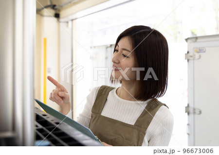 物流・運送業界　エプロン姿で働くアルバイトの女性 96673006