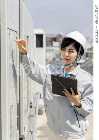 室外機を点検する女性作業員 96673097