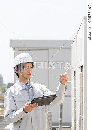室外機を点検する男性作業員 96673105