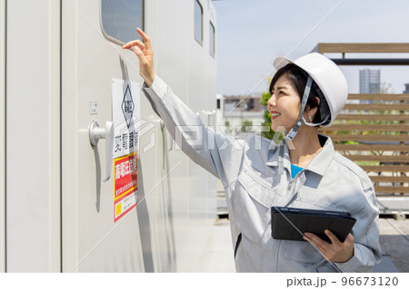 変電設備を点検する女性作業員 96673120