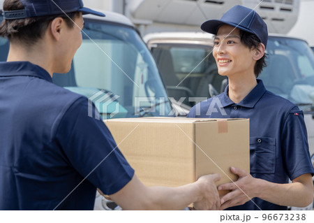 担当地域の配達員に荷物を渡す同僚 担当地域の配達員に荷物を渡す同僚 96673238
