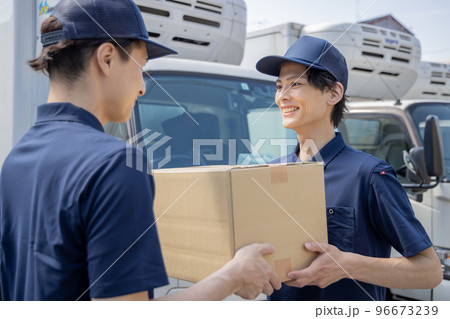 担当地域の配達員に荷物を渡す同僚 担当地域の配達員に荷物を渡す同僚 96673239