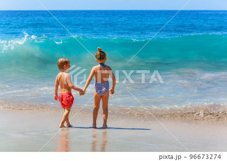Happy kids have fun in sea surf on sea beach. 96673274
