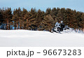 In deep powder snowdrift snowmobile rider driving fast. 96673283