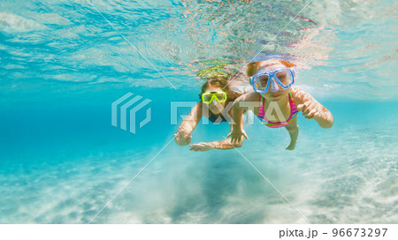 Kids in snorkeling mask dive underwater in blue sea lagoon Kids in snorkeling mask dive underwater in blue sea lagoon 96673297