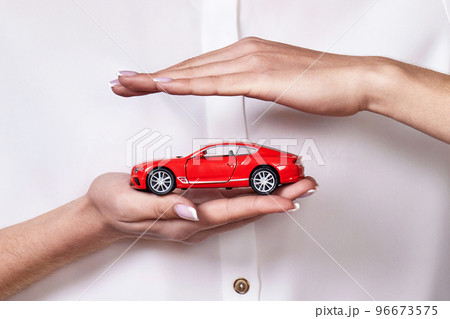 beautiful woman in white shirt holding little red car beautiful woman in white shirt holding little red car 96673575