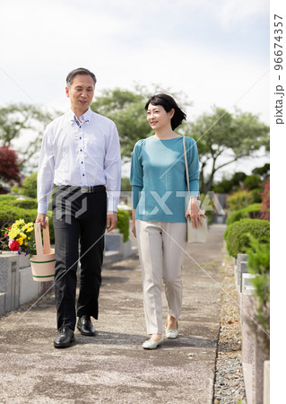 お墓参りをするミドル夫婦 96674357