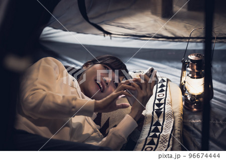 お家キャンプ　スマートフォンを使う女性 96674444