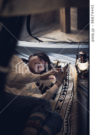 お家キャンプ　スマートフォンを使う女性 96674445