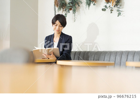 カフェで本を読む女性 96676215
