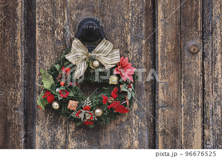 Christmas crown wreath upon an old wooden door. Traditional home decor during Christmas, copy space Christmas crown wreath upon an old wooden door. Traditional home decor during Christmas, copy space 96676525