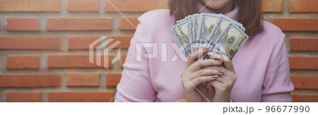 Close up of woman holding dollar bills. 96677990