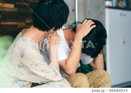 落ち込む夫を心配する妻 96680024