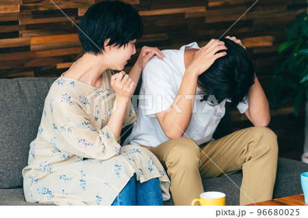 落ち込む夫を心配する妻 96680025