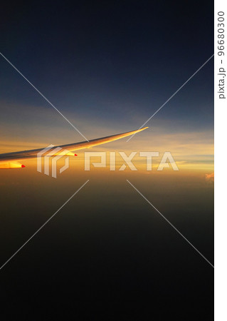飛行機の窓から広がる夕暮れ 96680300