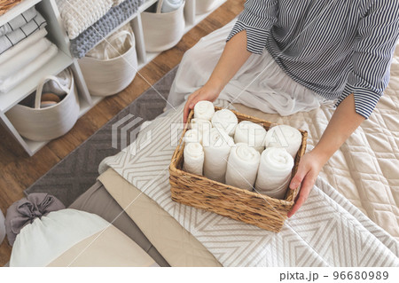 Woman hands neatly folded linens and towels. Japanese storage method. Woman hands neatly folded linens and towels. Japanese storage method. 96680989