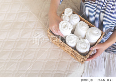 Woman hands neatly folded linens and towels. Japanese storage method. Woman hands neatly folded linens and towels. Japanese storage method. 96681031