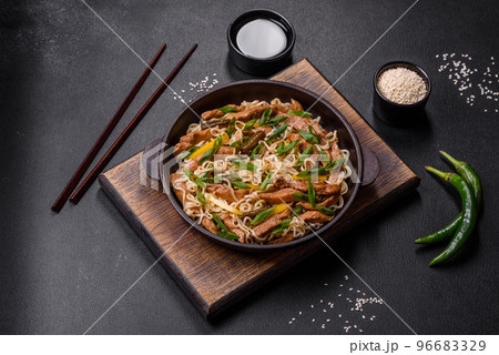 Tasty dish of Asian cuisine with rice noodles, chicken, asparagus, pepper, sesame seeds and soy sauce Tasty dish of Asian cuisine with rice noodles, chicken, asparagus, pepper, sesame seeds and soy sauce 96683329
