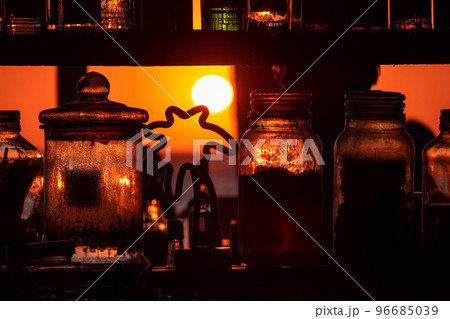 Boracay, Philippines - Jan 21, 2020: Sunset on the background of bottles standing on the bar. The sun passes through the bright glass of the bottles. Background image for the screensaver. Boracay, Philippines - Jan 21, 2020: Sunset on the background of bottles standing on the bar. The sun passes through the bright glass of the bottles. Background image for the screensaver. 96685039